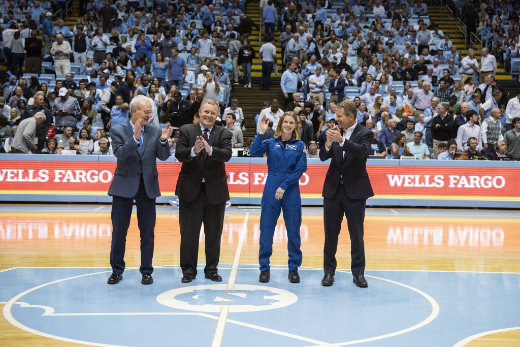 Terry Magnuson, Jim Morhard, Zena Cardman, and Kevin Guskiewicz stand at center-court at the Dean Dome