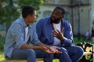 a black father talks with his son