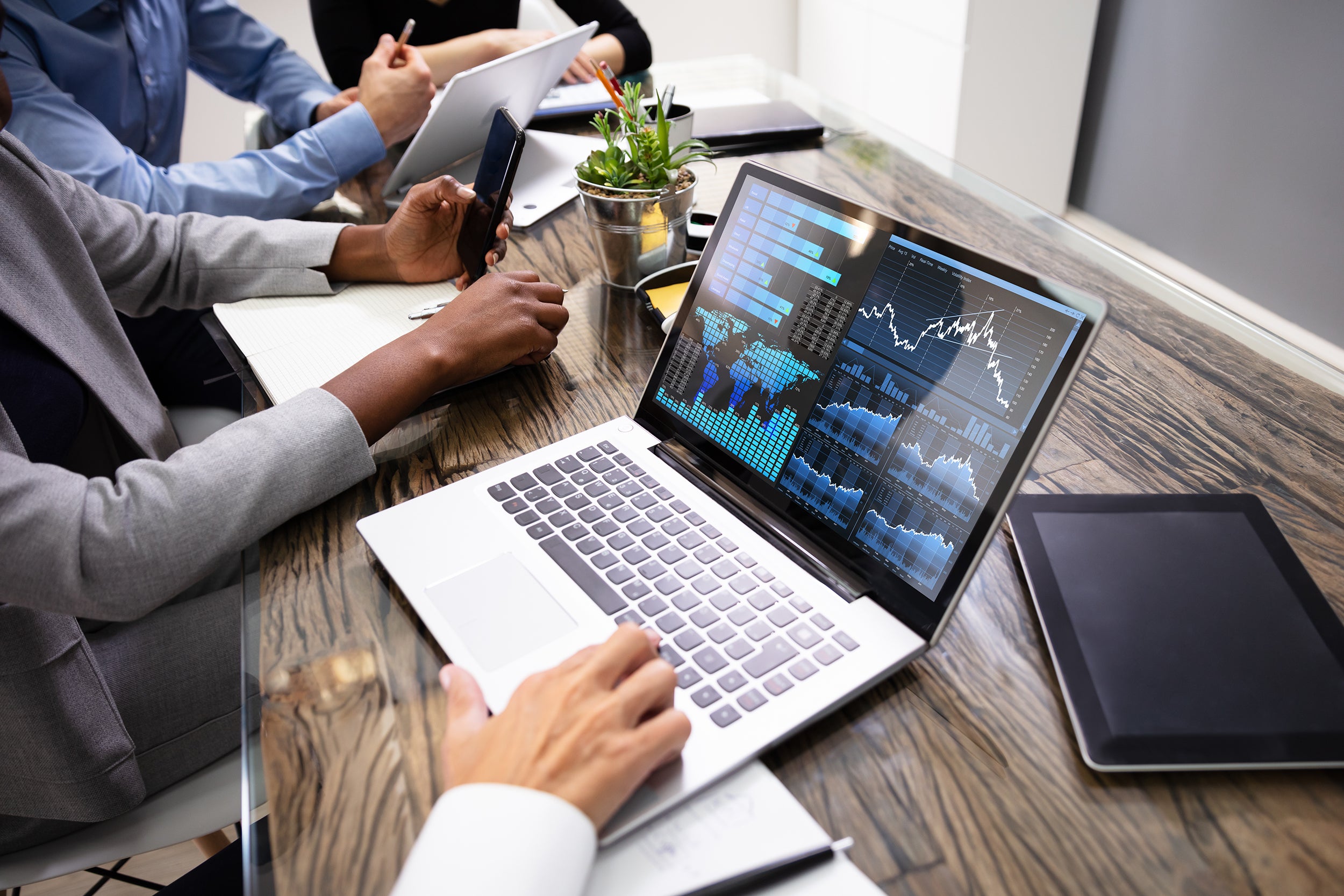 Side View Of Businesspeople Examining Graph On Computer At Workplace