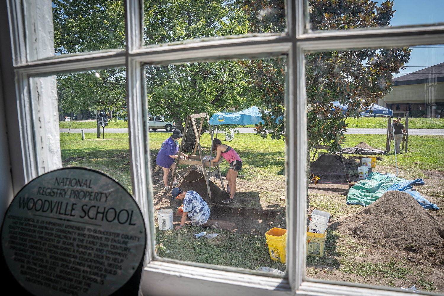 researchers work outside a window at the Woodville School