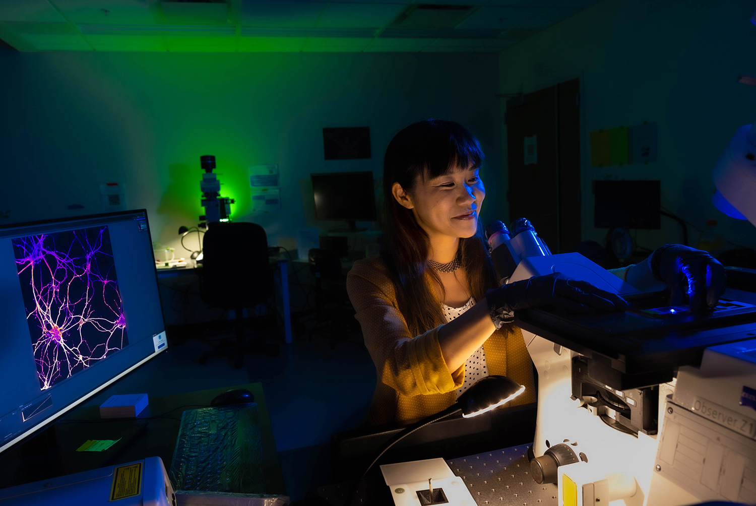 Michelle Itano looks at microscope slides in the UNC Neuroscience Microscopy Core