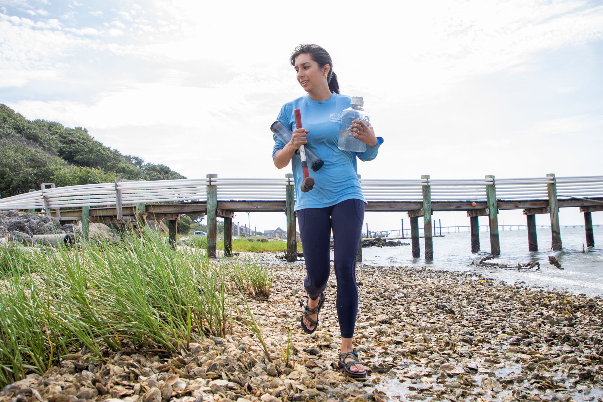 Anne Smiley holds tubes as she heads into the marsh