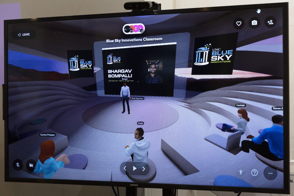 A photo of how the metaverse classroom looks. There are people's avatars seated and Bhargav Bompalli stands at the front of the room, presenting through his avatar.