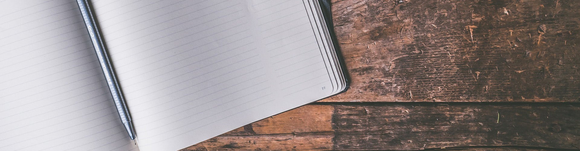 Stock photo of a blank notebook lying on a wooden table