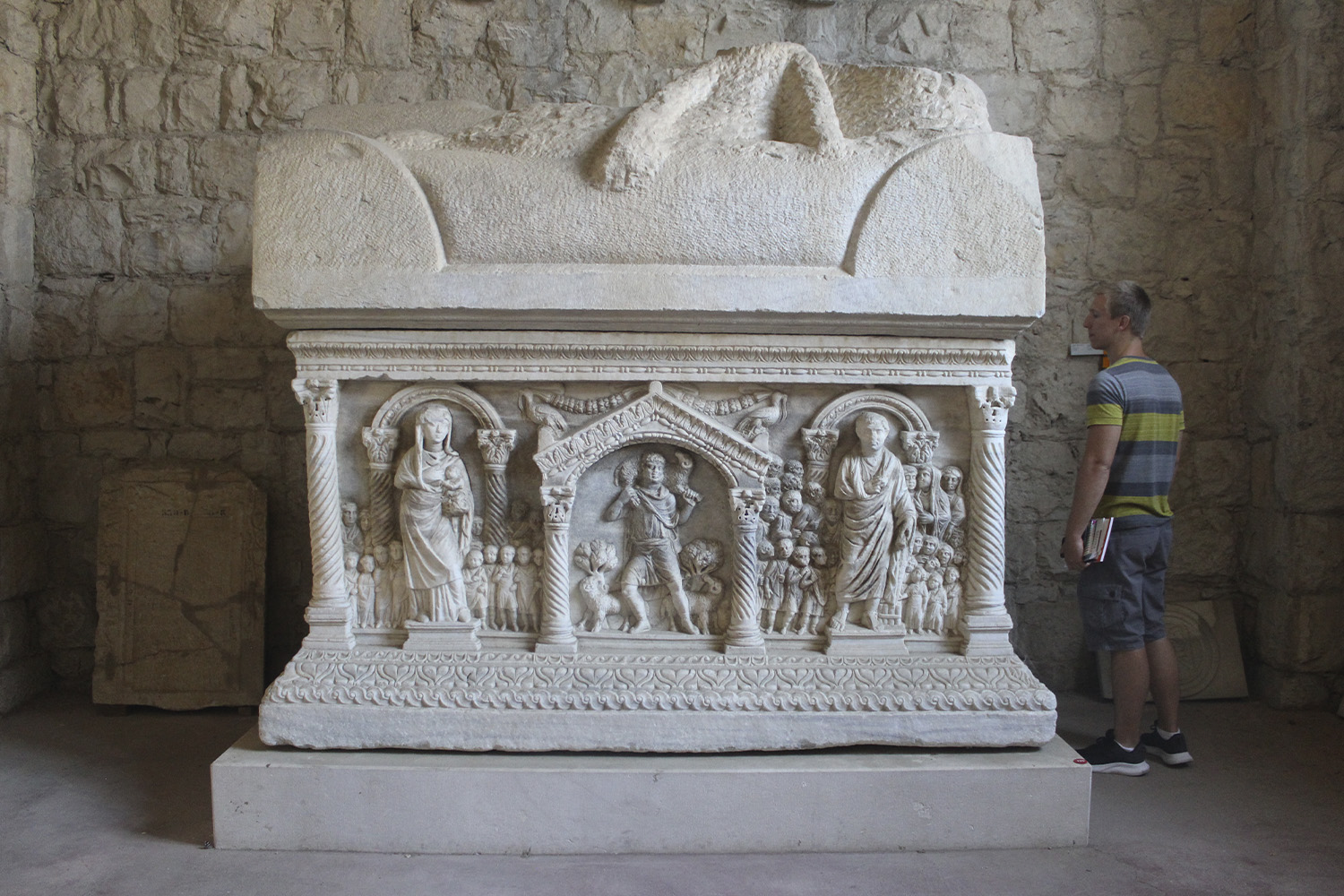 Michelle Freeman's husband stands next to a sarcophagi from Manastirine