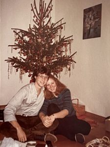 A young Cindy Bulik and Patrick Sullivan sitting in front of a Christmas tree.