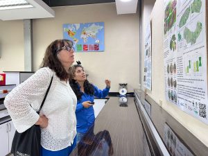 Two women look at a poster board together.