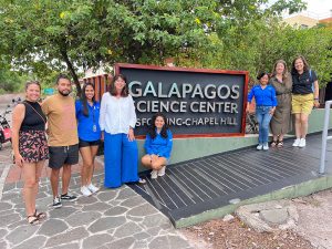 A group of people standing outside in front of a sign that says Galapagos Science Center.