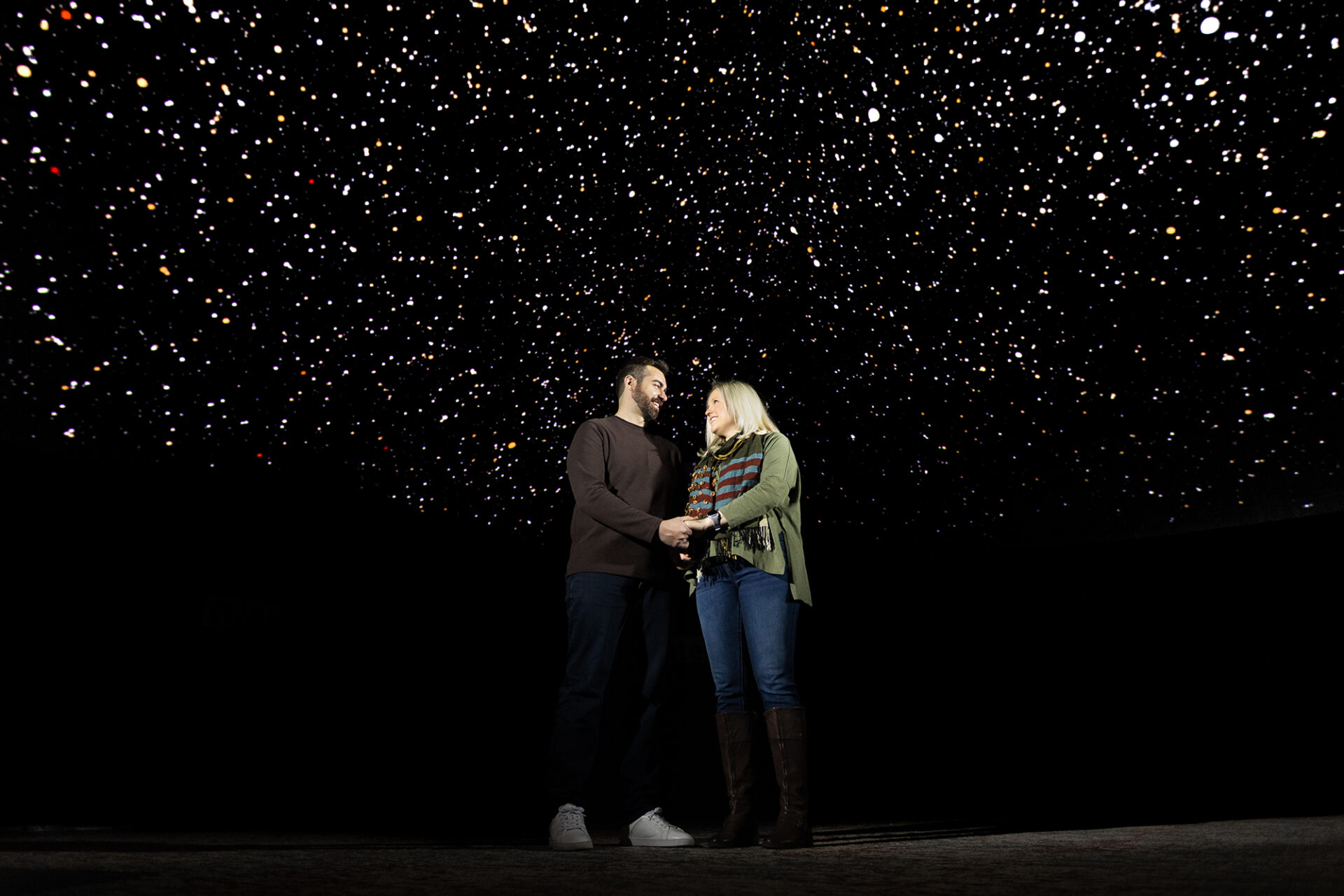 Manuel and Megan Maeso under the starry sky of the full dome theater at Morehead Planetarium