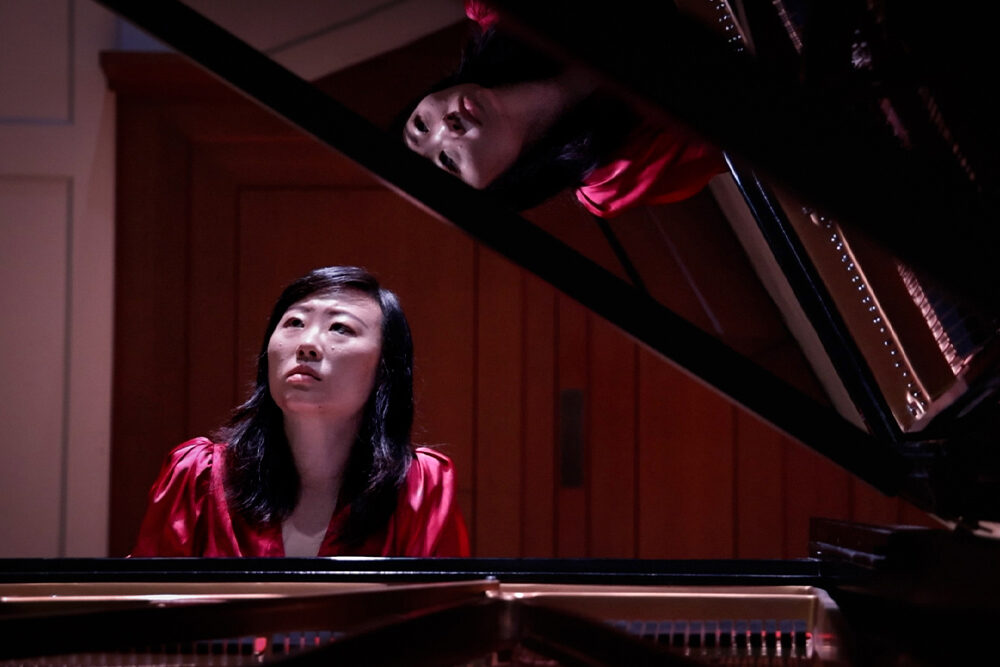 a woman playing a grand piano.