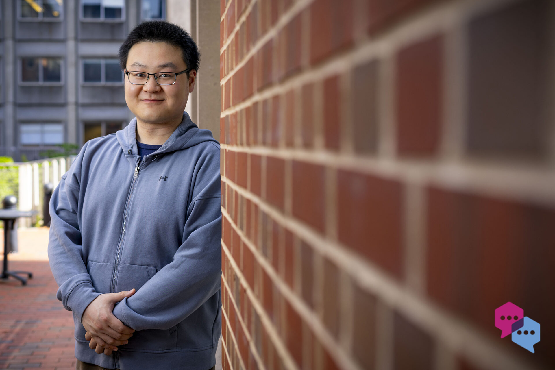 a man leans against a brick wall