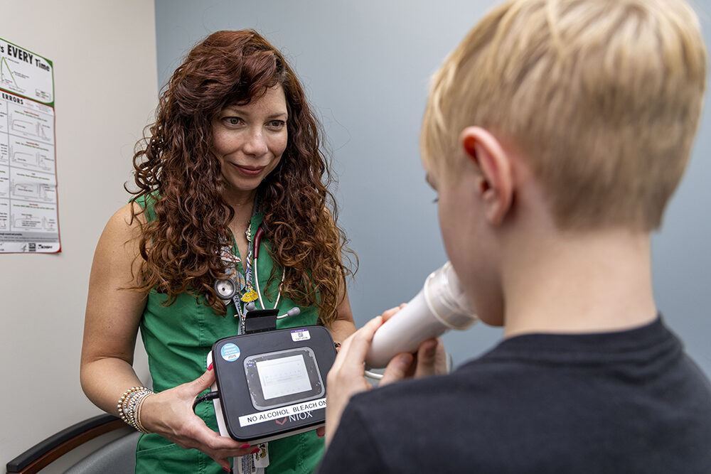 a woman administers a breathing test with a young boy