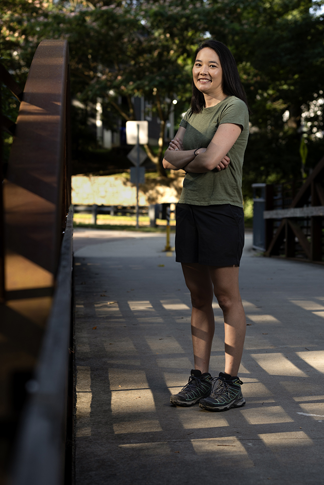 a woman stands on a bridge 