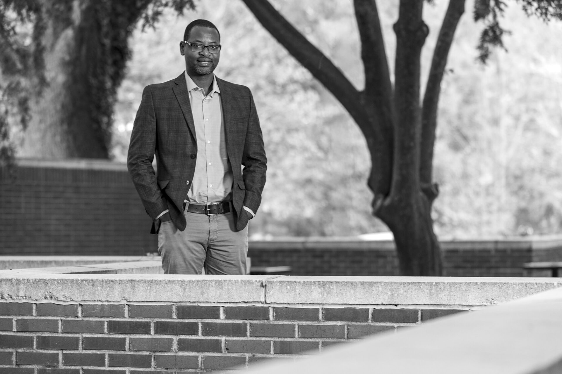 a man stands amid a brick wall on UNC-Chapel Hill's campus