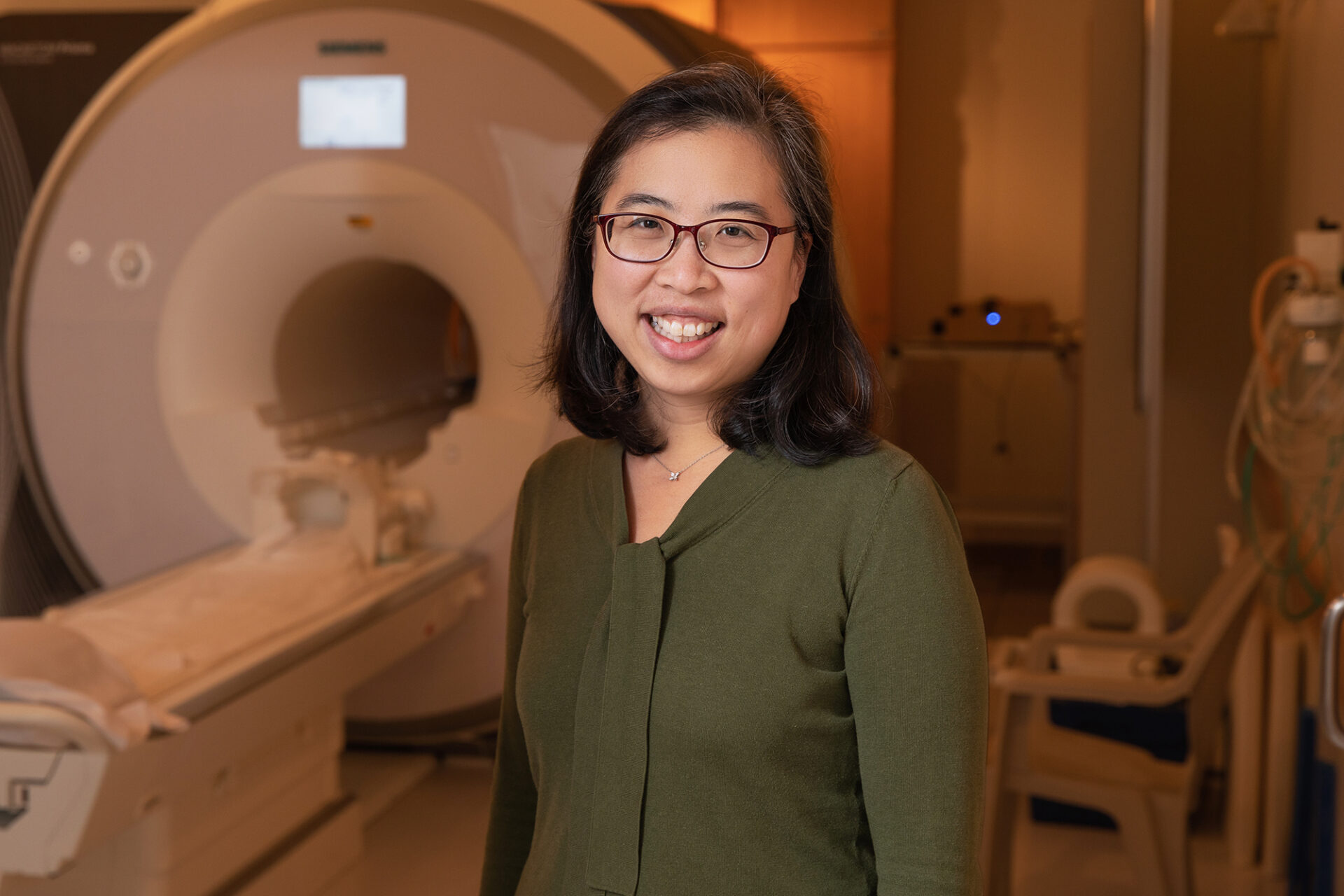 Janice Hwang stands in front of an MRI machine