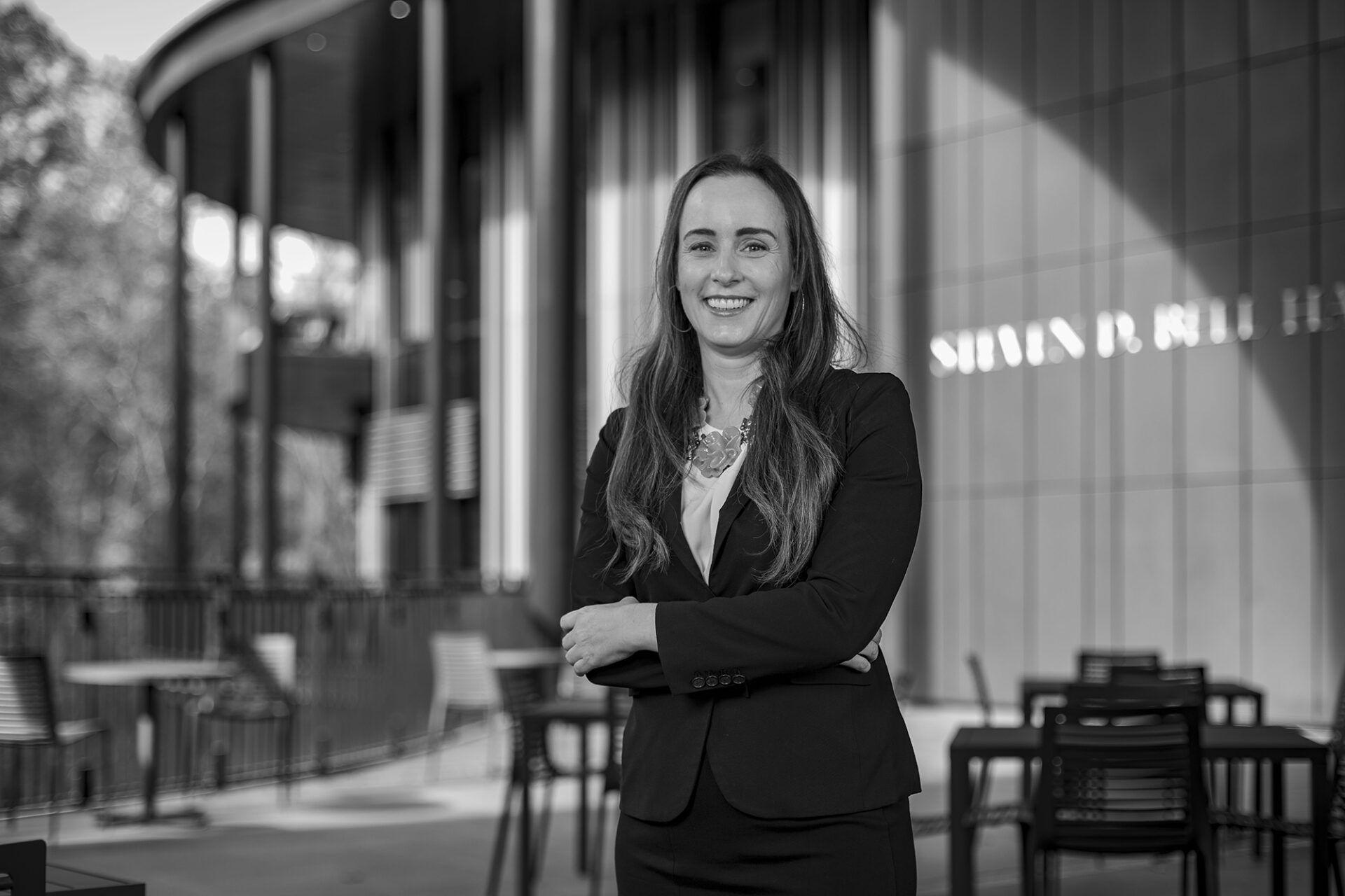 a woman stands in front of Bell Hall on UNC's campus