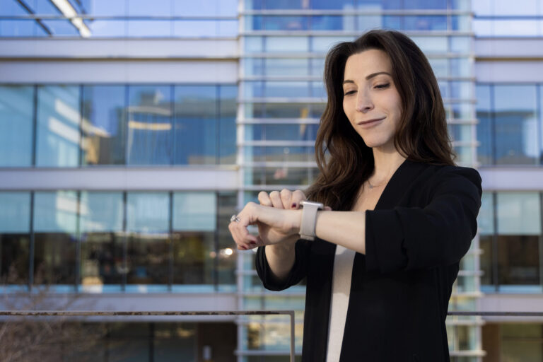 Lindsey Rosman looks at her smartwatch in front of UNC Hospitals