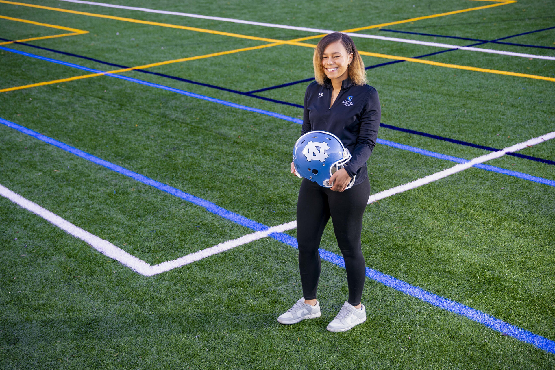Kennedy Kehaulani Guess holds a football helmet in the corner of Hooker Field