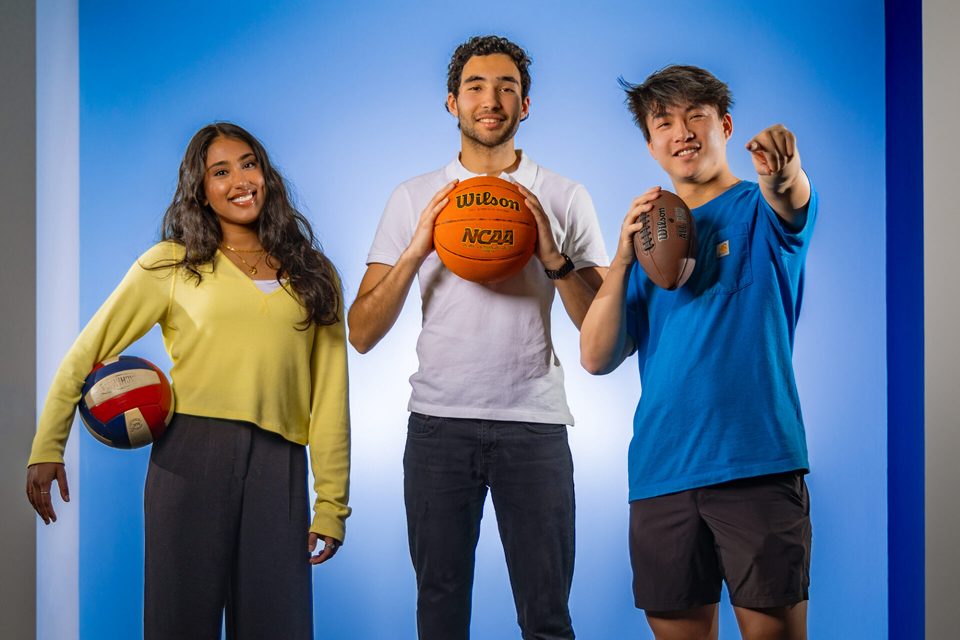 Khushi Shah with a volleyball, Yunus Mouline with a basketball, and Gordan Tao with a football