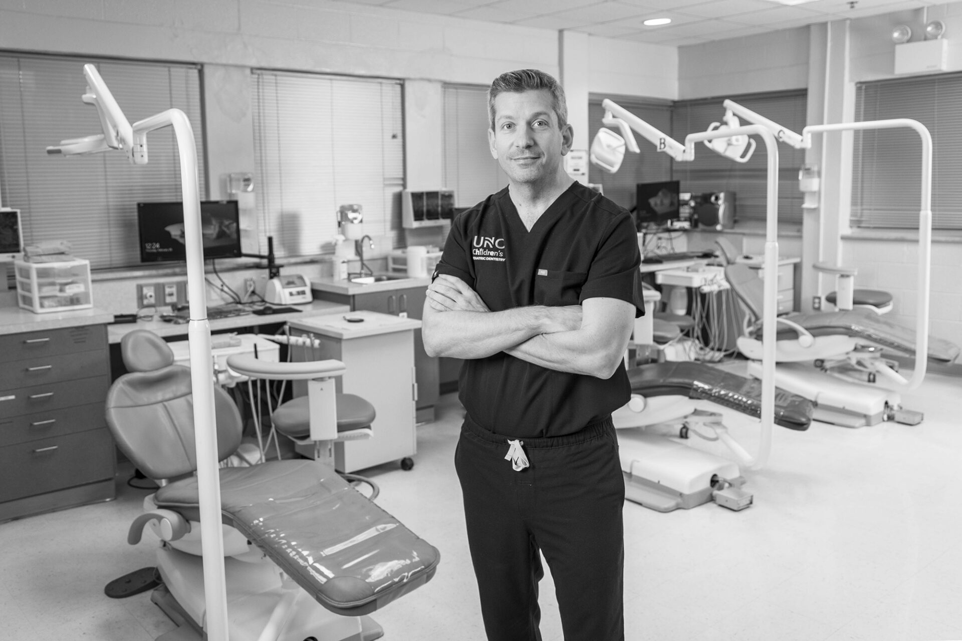 a man stands in a dental clinic surrounded by patient chairs