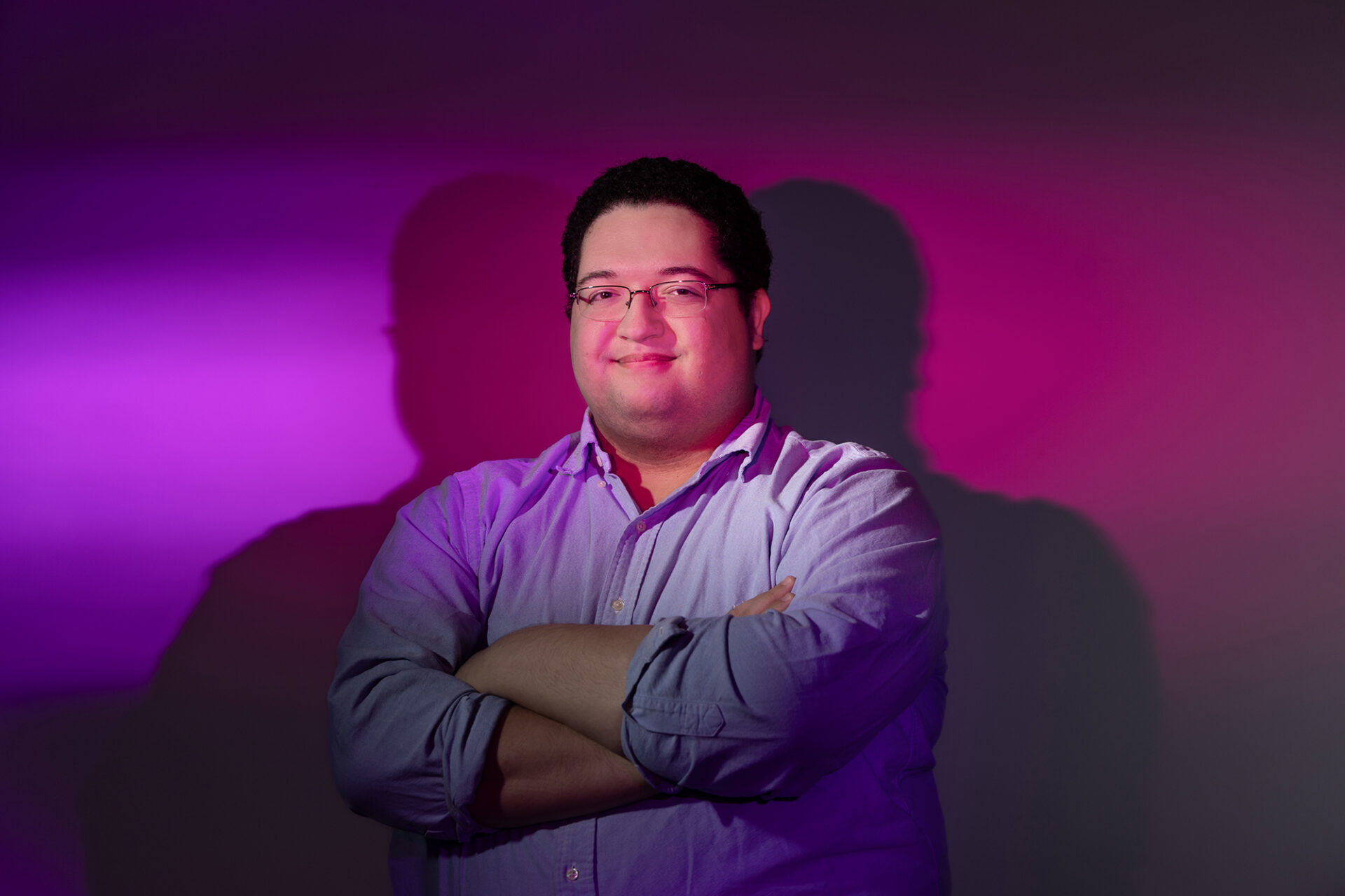 a young man is lit with purple and pink lights