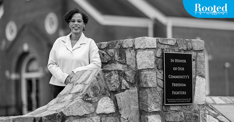Karla Slocum standing next to an open air memorial for freedom fighters