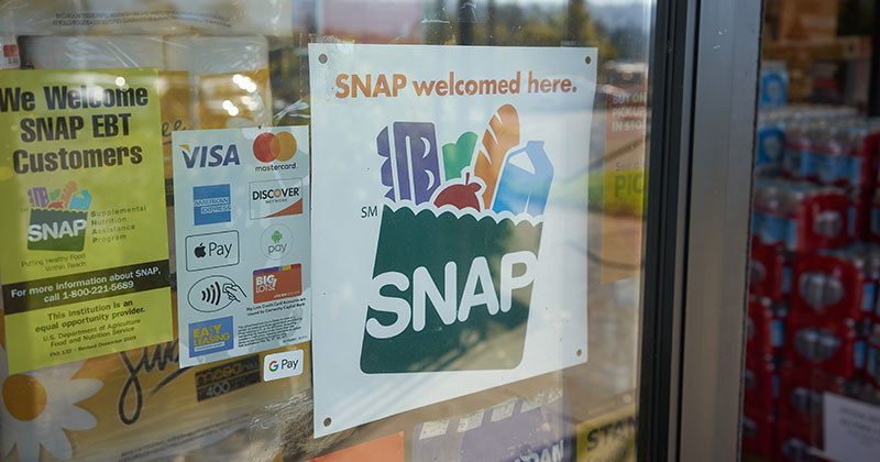A sign in a grocery store window that says "SNAP accepted here."