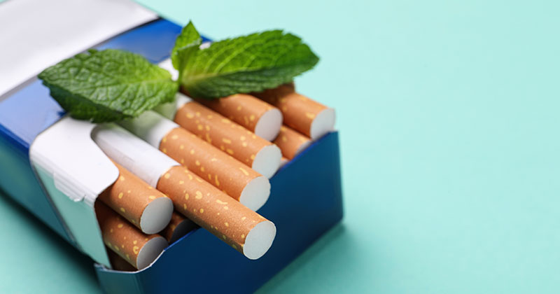 A carton of cigarettes with a mint leaf on top
